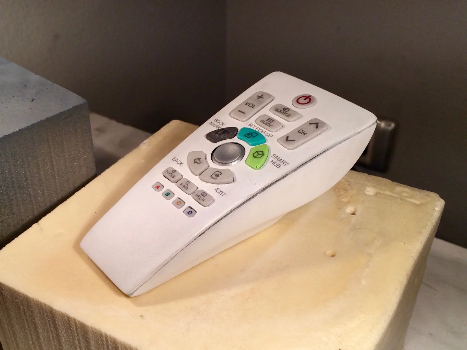 Finished white Uni remote appearance model on a foam block